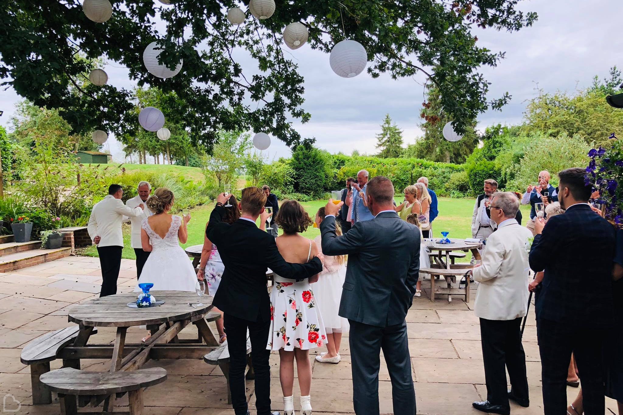 wedding guests toast outside in forrester park wedding venue