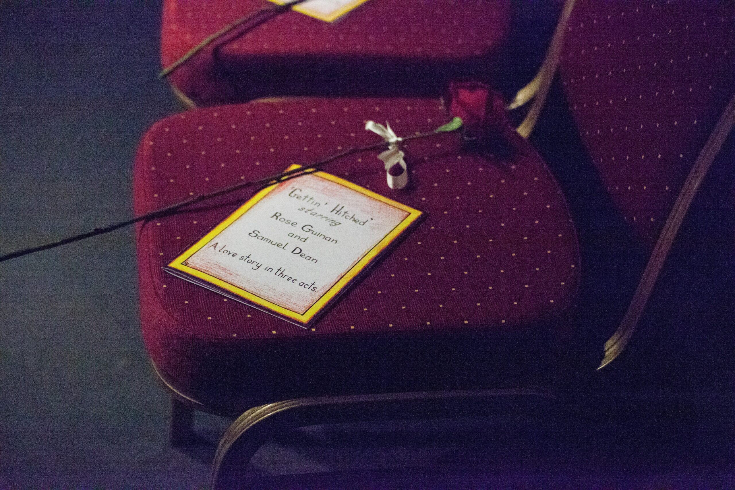 Bridebook.co.uk order of service and rose on theatre chair