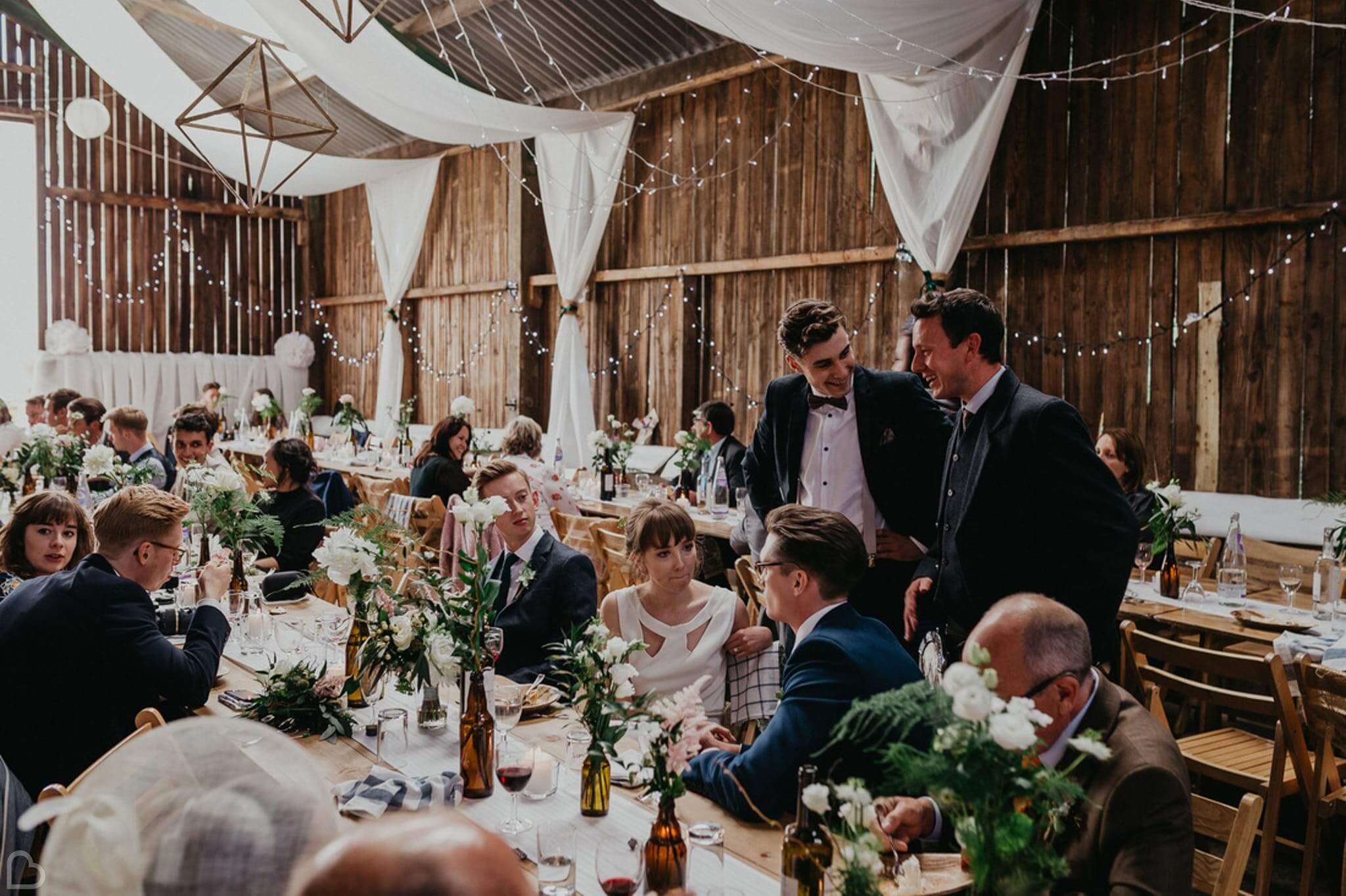 guests laugh and chatter at deepdale farm, a barn wedding venue in yorkshire