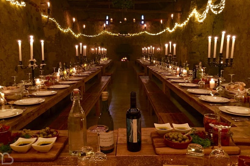 a candlelit table for many wedding guests in Eggbeer Farm, Devon