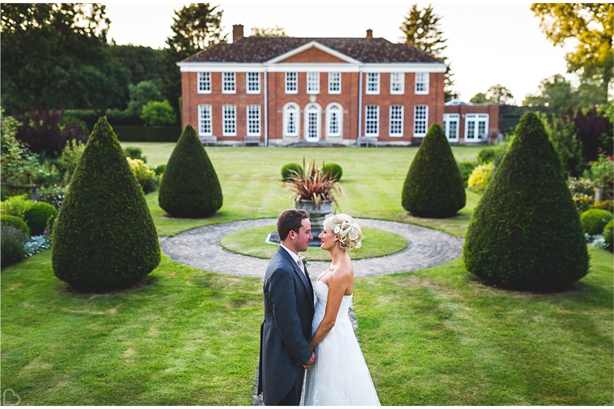 newlyweds pose in front of hockering house a country wedding venue in the uk 