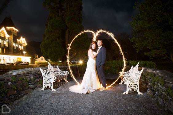 Married couple pose outside The Lodore Falls Hotel a wedding venue in Cumbria