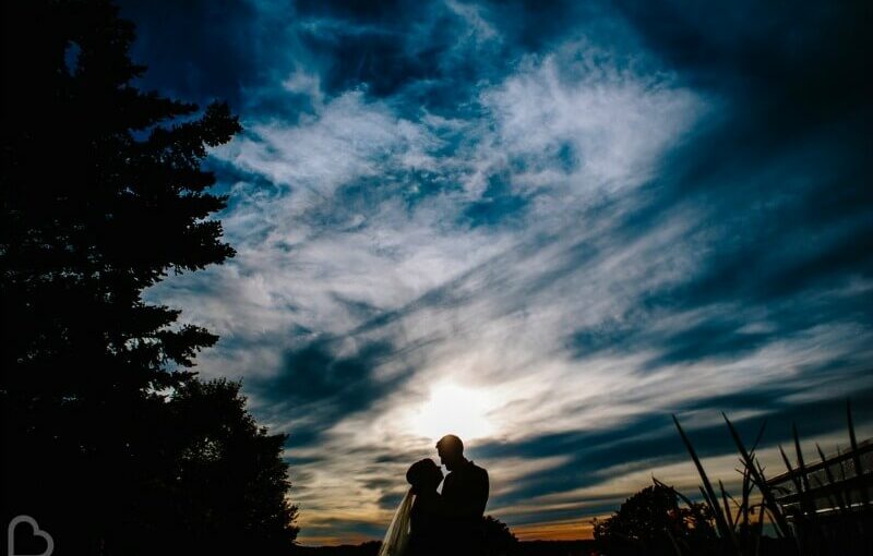 twilight couple kissing in front of sky