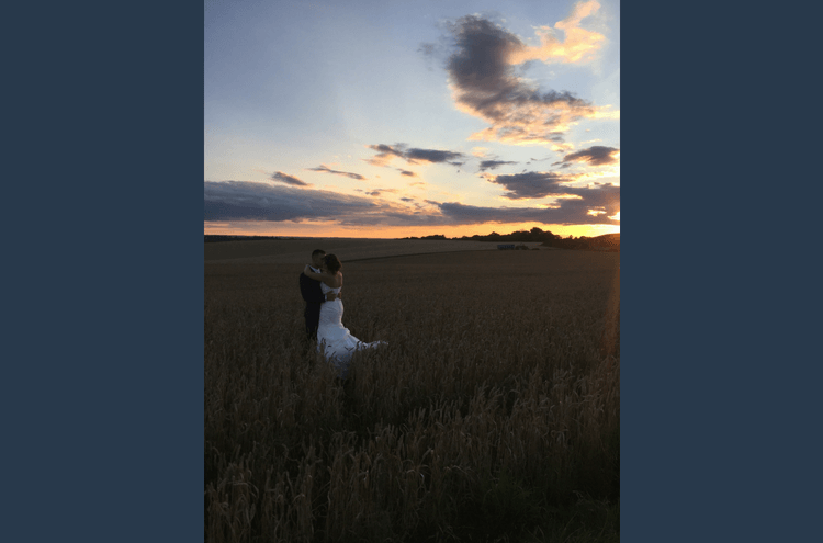 Bridebook.co.uk bride and groom in wheat field at twilight