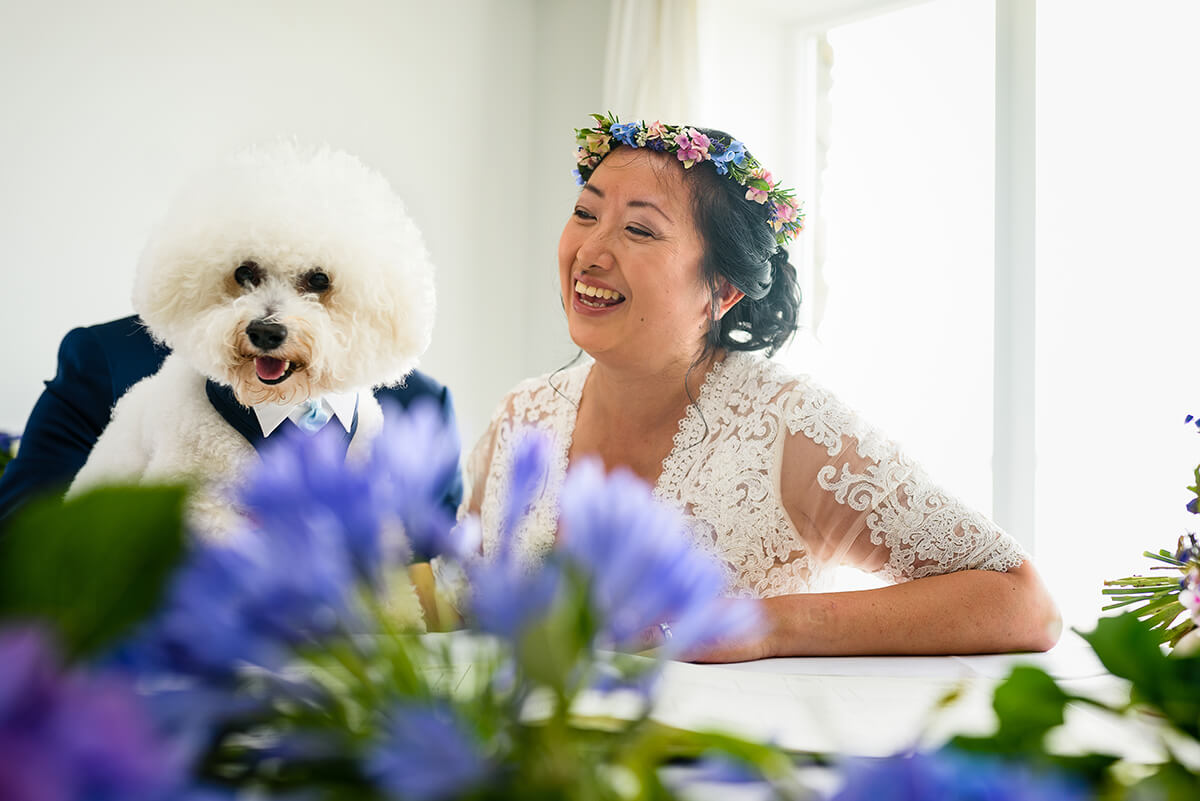 bride laughs as it looks like her dog is her groom