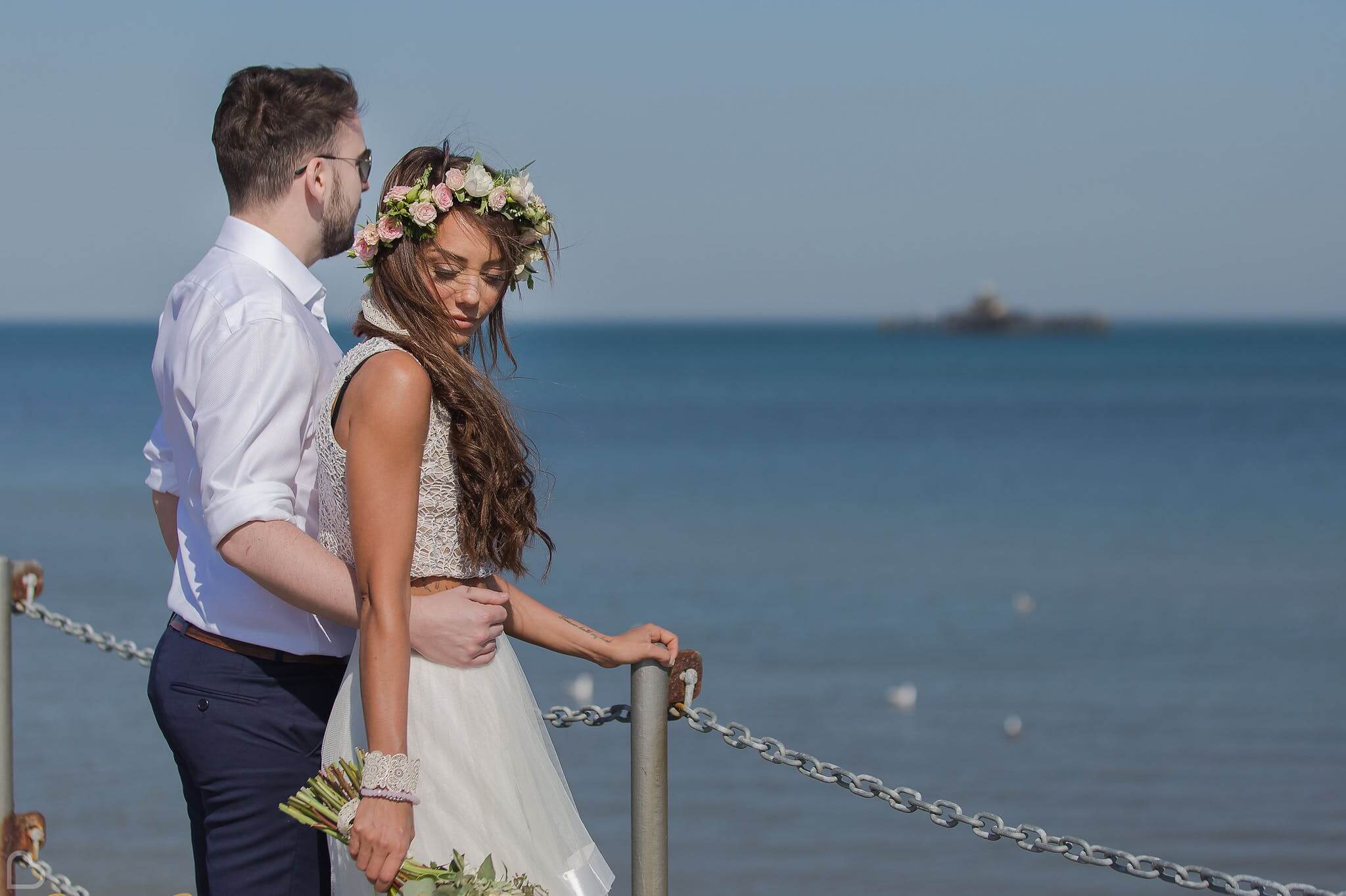 beach hut weddings bride and groom pose by the sea