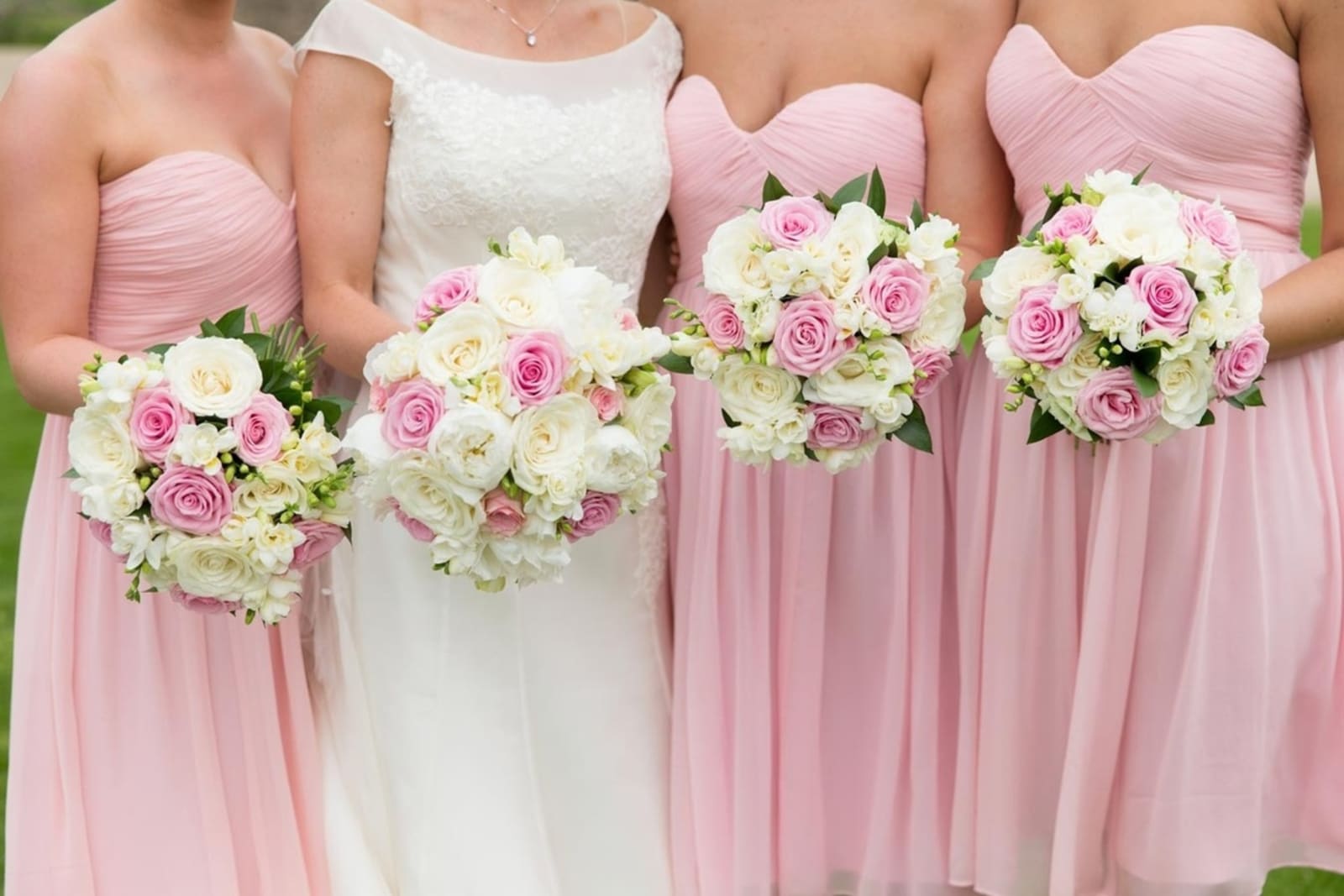 Bridebook.co.uk- bride and bridesmaids holding up white and pink bouquets