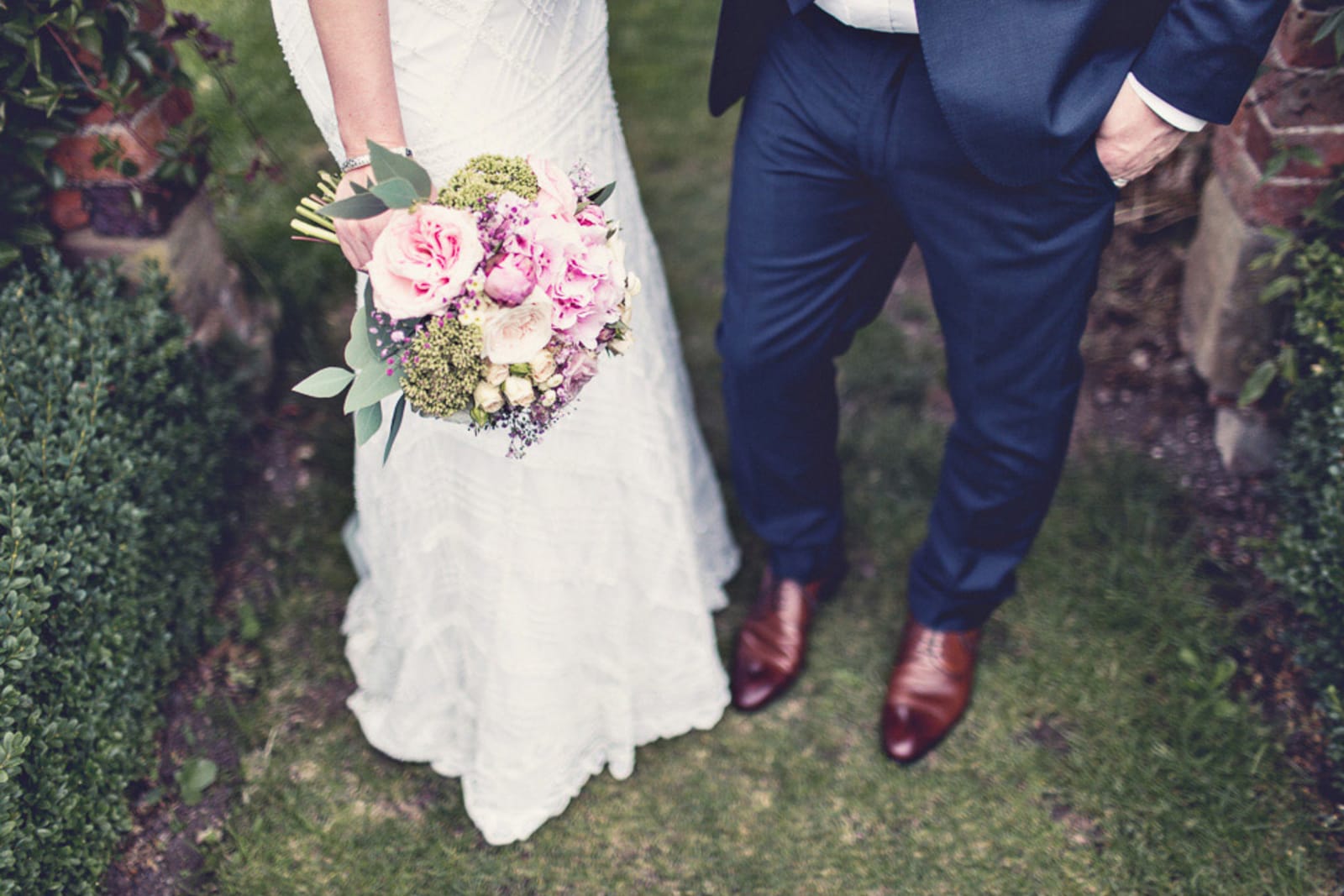 Bridebook.co.uk- bride and groom with bride holding a pink bouquet