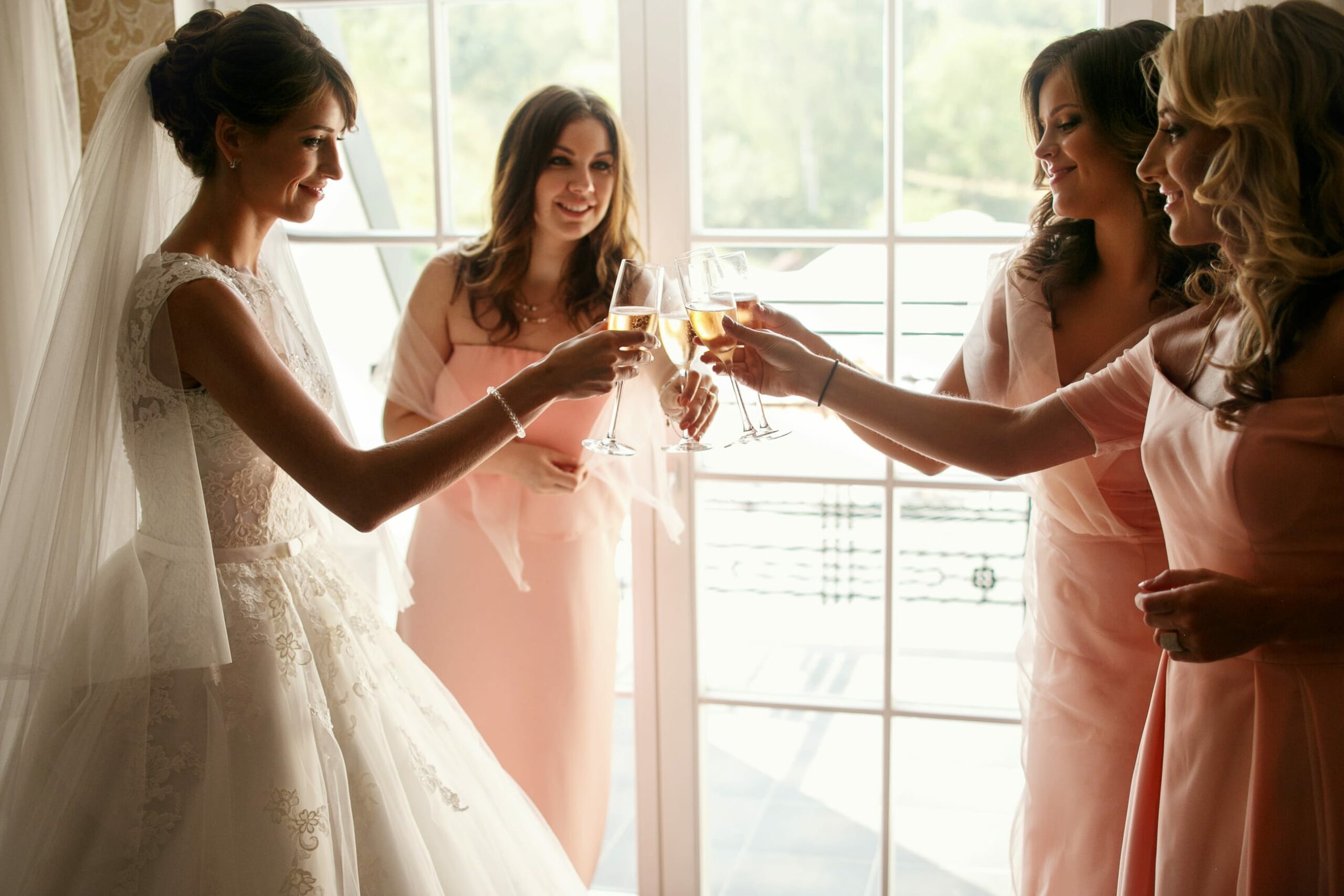 Bridebook.co.uk bride drinking champagne with bridesmaids
