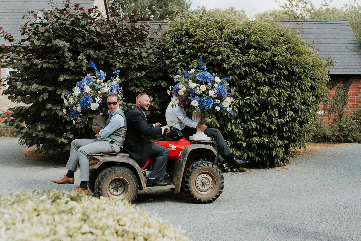 groomsmen carrying flowers on a truck