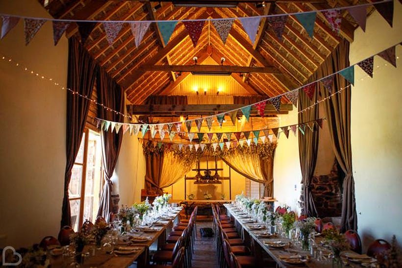 Duvale Priory, a wedding venue in Devon, decorated with flags and tables set for many wedding guests