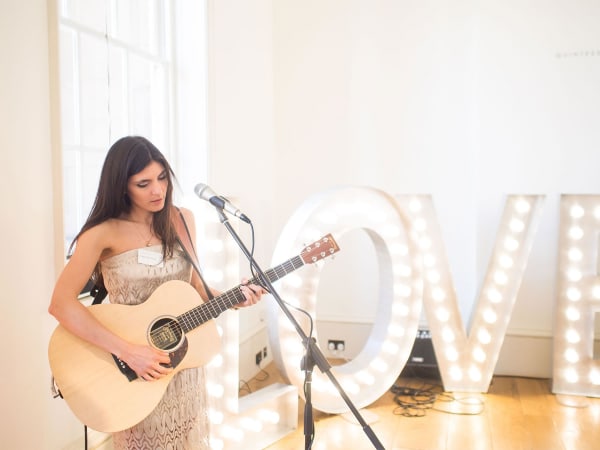bridebook.co.uk girl with guitar playing at a wedding