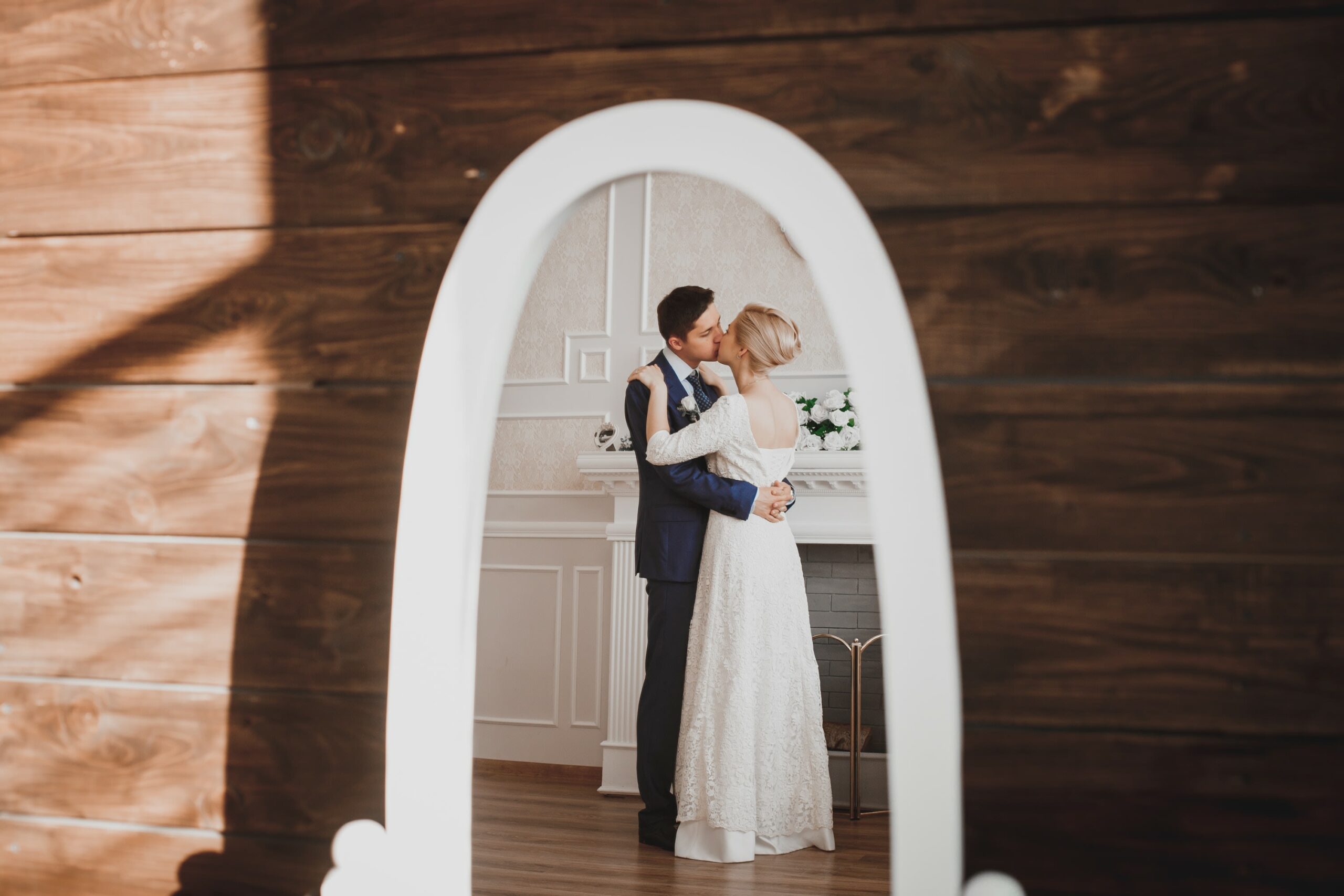 Bridebook.co.uk Couple kissing in reflection of dresser mirror